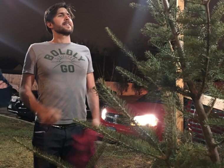 A man stands outdoors at night near a boho-inspired Christmas tree under string lights, with parked cars and another person visible in the background. Soul Flower Blog: Hippie Style & Kind Living
