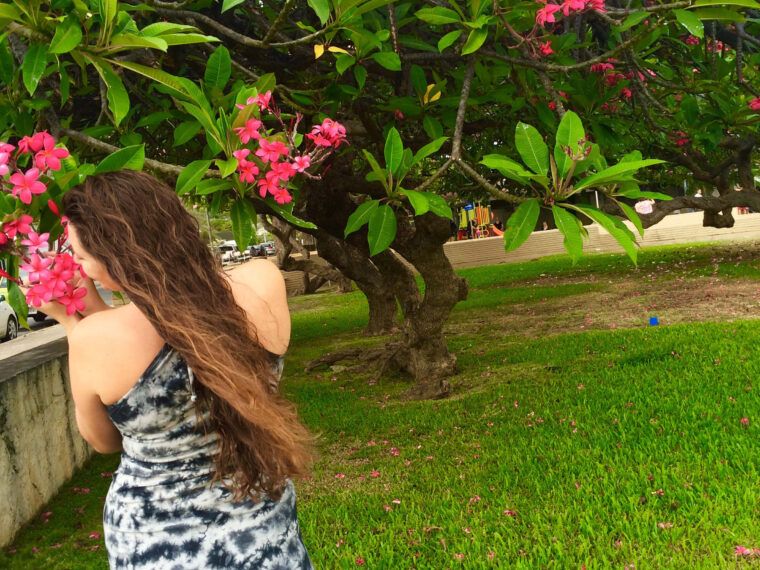 A person with long brown hair in a boho tie-dye dress stands on grass near a large tree with pink flowers. The SOUL FLOWER logo is visible in the bottom right corner. Soul Flower Blog: Hippie Style & Kind Living