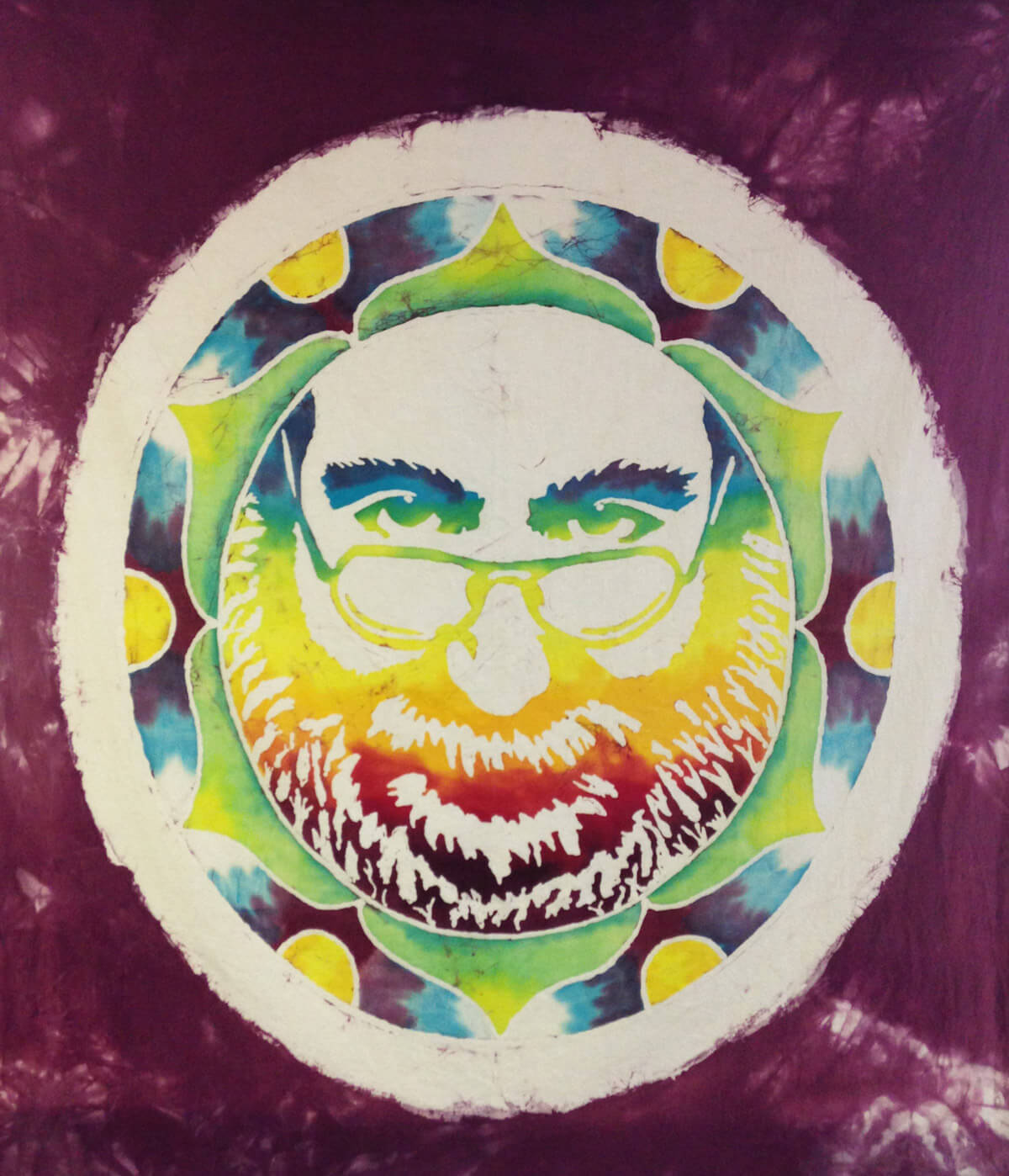 A boho tie-dye style circular artwork depicting a bearded man with glasses in yellow, green, and red tones, set against a maroon background. Soul Flower Blog: Hippie Style & Kind Living