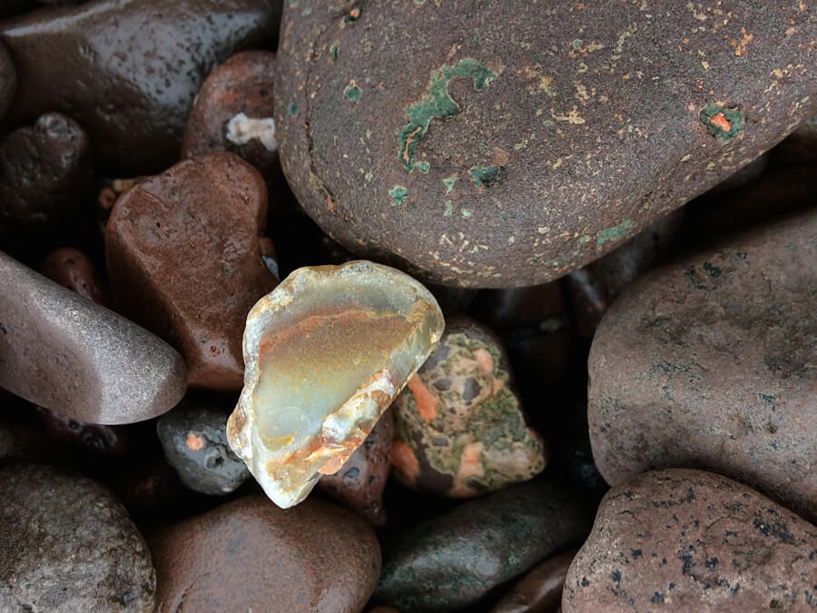 A variety of smooth, brown and grey stones with one translucent, light-colored stone in the center, perfect for adding a touch of boho charm to your space. Soul Flower Blog: Hippie Style & Kind Living