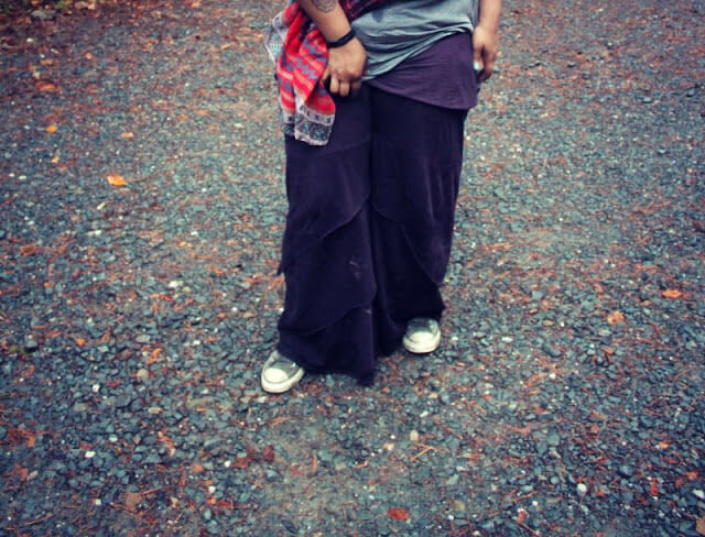 Person standing on a gravel path during My First Hiking Adventure, wearing dark loose pants, sneakers, a gray shirt, and a red-patterned scarf; their upper body is mostly out of frame. Soul Flower Blog: Hippie Style & Kind Living