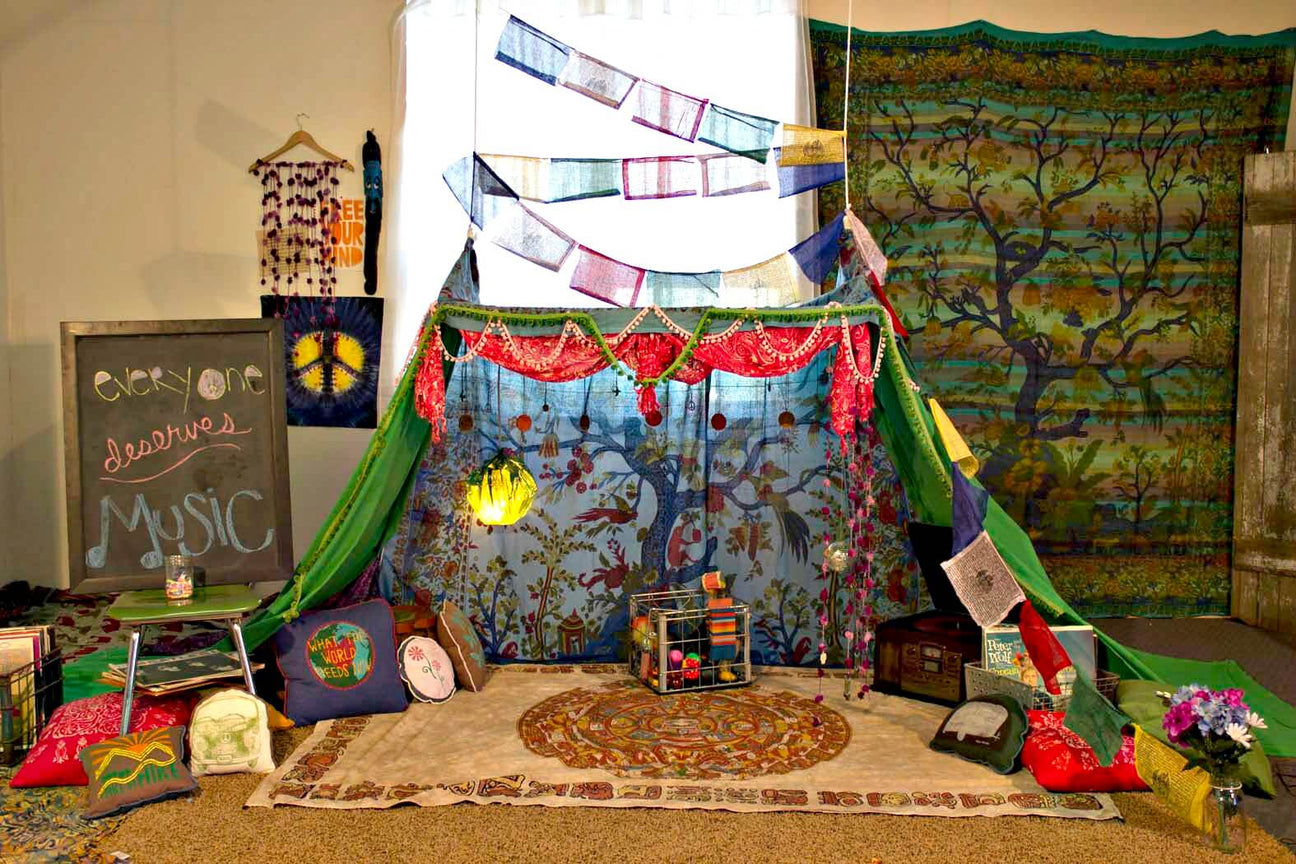A colorful indoor fort, inspired by How To Build An Indoor Fort, features tapestries, fabric banners, pillows, rugs, string lights, and a chalkboard sign that reads “Everyone deserves music.”. Soul Flower Blog: Hippie Style & Kind Living