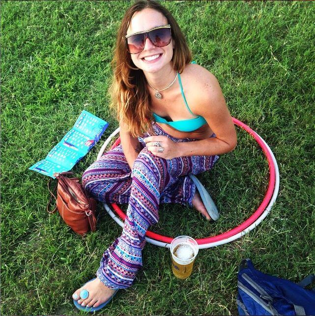 A woman in sunglasses and patterned boho pants sits on grass inside a hula hoop, smiling at the camera. Nearby are a drink, a map, and a bag. Soul Flower Blog: Hippie Style & Kind Living
