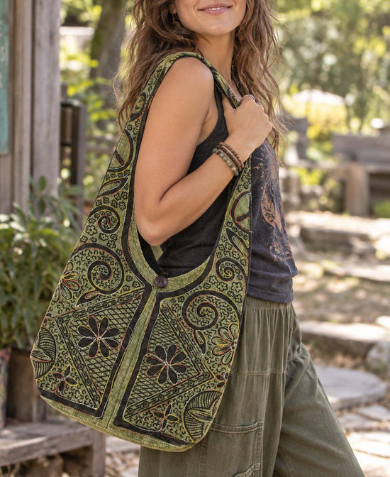 Boho Bag in Green with stitching and cut outs. On model outside.