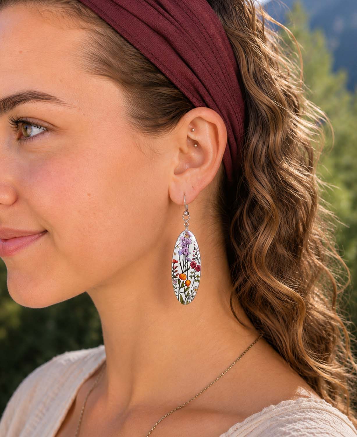 A close-up side profile of a woman wearing a danglingearring from Soul Flower called Wild Bloom Earrings