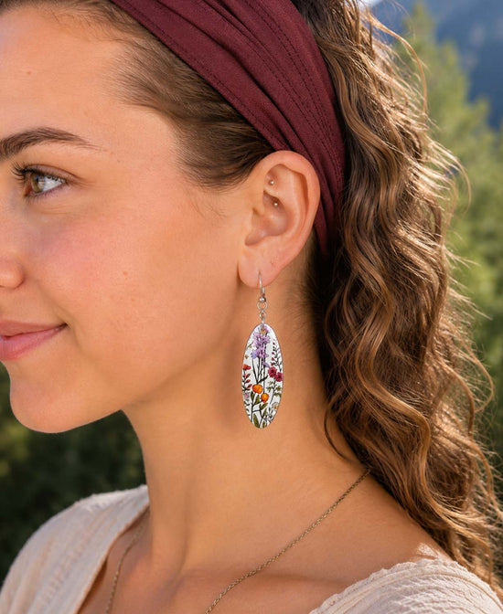 A close-up side profile of a woman wearing a danglingearring from Soul Flower called Wild Bloom Earrings